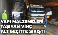 Yapı malzemeleri taşıyan vinç alt geçitte sıkıştı