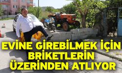 Evine girebilmek için briketlerin üzerinden atlıyor