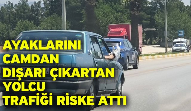 Ayaklarını camdan dışarı çıkartan yolcu trafiği riske attı